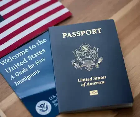 American passport on an immigration guide next to a small flag.